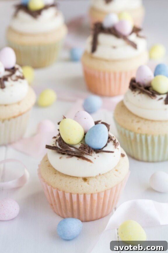 White Chocolate Easter Egg Cupcakes, topped with pastel candy eggs.