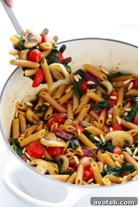 Delicious Whole Wheat Pasta with Sautéed Mushrooms, Sun-Dried Tomatoes, and Fresh Spinach in a Light White Wine Garlic Sauce – a perfect 30-minute meal for busy weeknights.