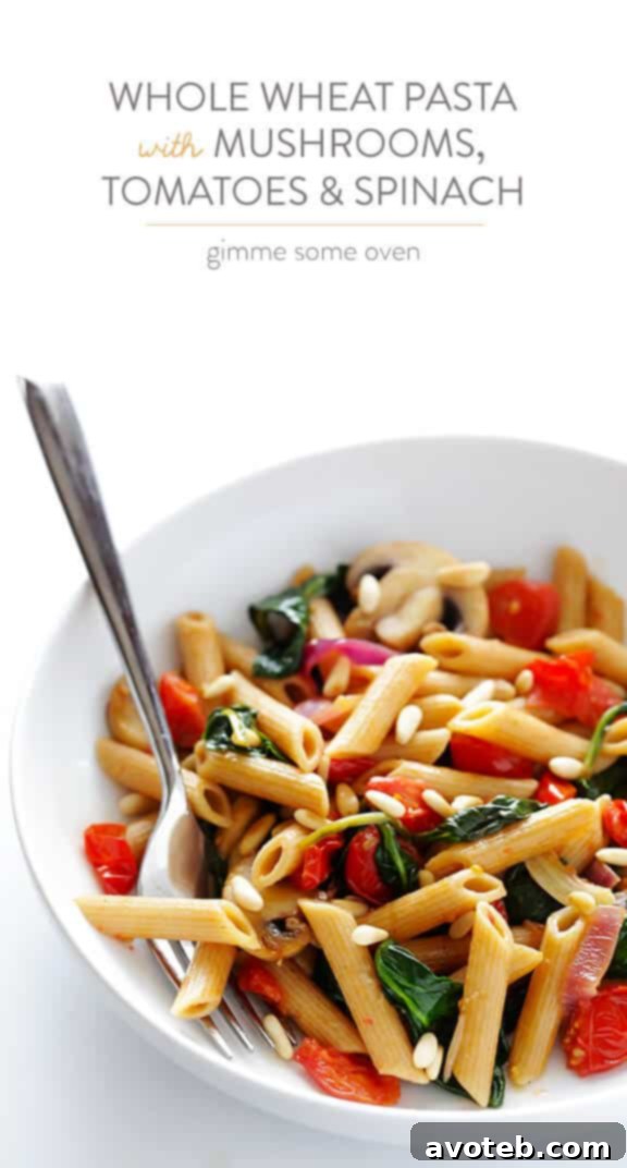 A vibrant bowl of Whole Wheat Pasta with Mushrooms, Tomatoes, and Spinach, garnished with fresh herbs, ready for a comforting meal.