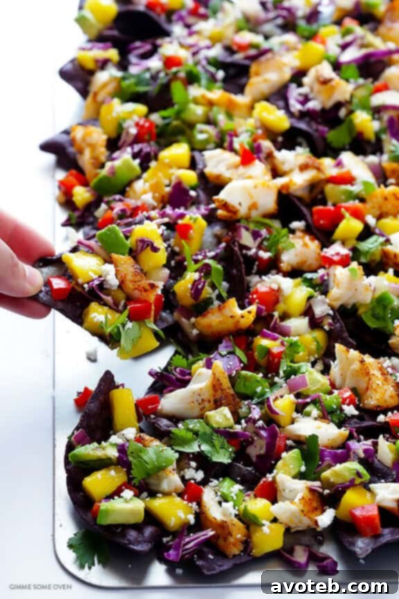 A bowl of freshly prepared, colorful mango slaw, ready to be layered onto the fish taco nachos.