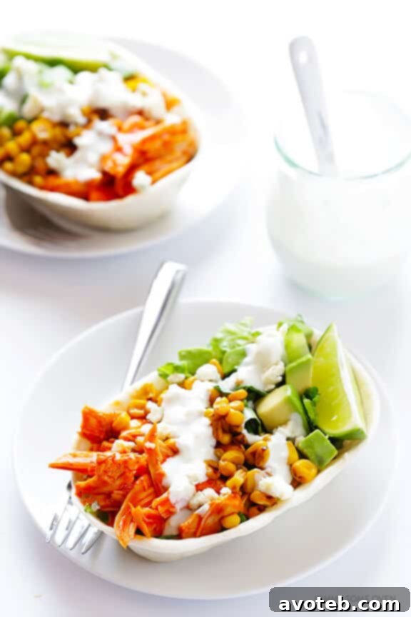A plate of two Buffalo Chicken Taco bowls, topped generously with blue cheese crumbles and cilantro.