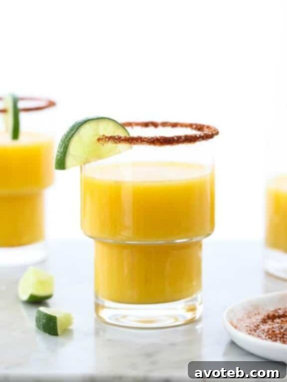 15 Must Try Margarita Creations 5 A refreshing mango margarita, beautifully garnished with a chile salt rim and a fresh lime wedge, evoking tropical heat.
