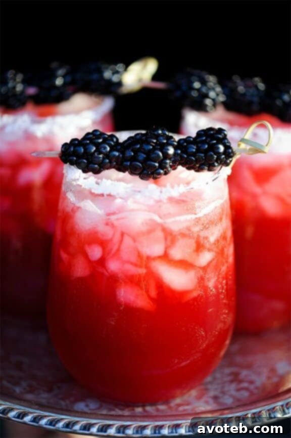 15 Must Try Margarita Creations 7 A deep purple blackberry margarita, elegantly garnished with fresh blackberries, promising a rich and fruity experience.