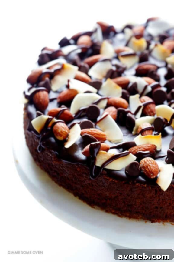 A slice of Almond Joy Cheesecake ready to be served, highlighting the layers of crust, chocolate filling, and luscious toppings.