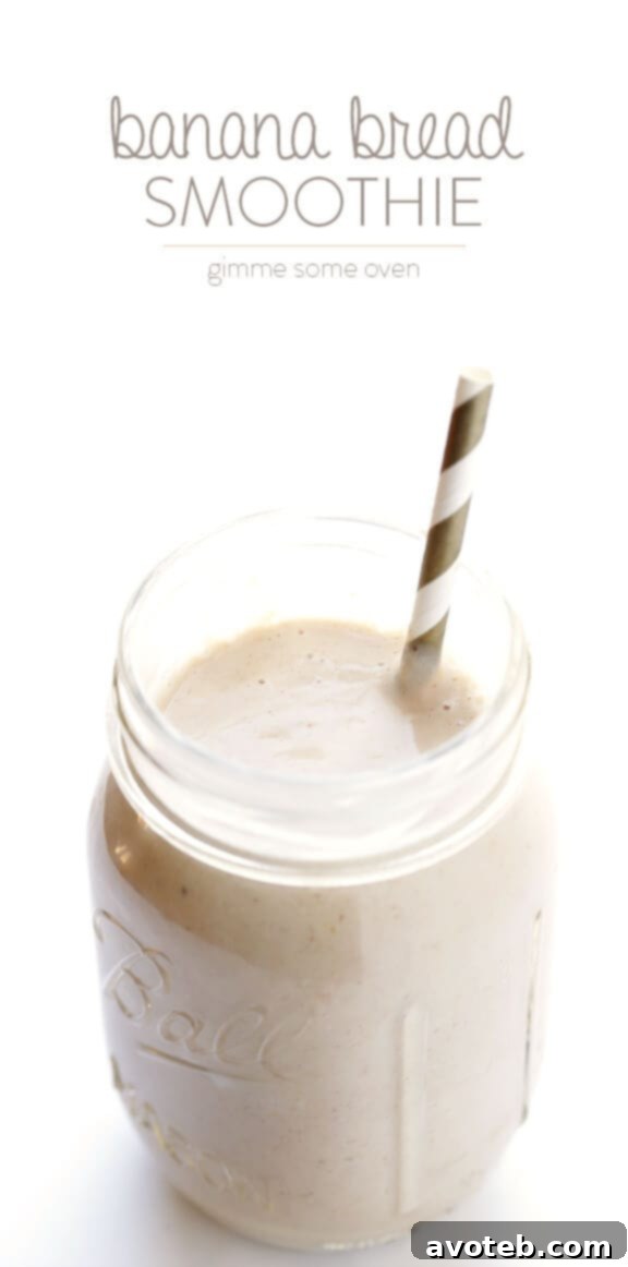 Liquid Banana Bread 10 A tall glass of Banana Bread Smoothie, garnished with a banana slice and a sprinkle of cinnamon, against a light background.