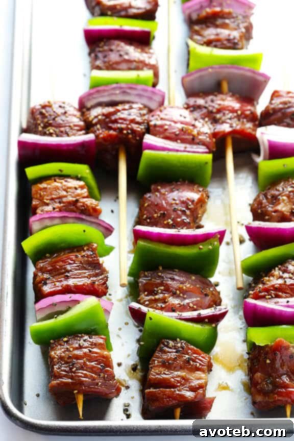 Skewering Asian Pepper Steak Kabobs with vibrant bell peppers and onions