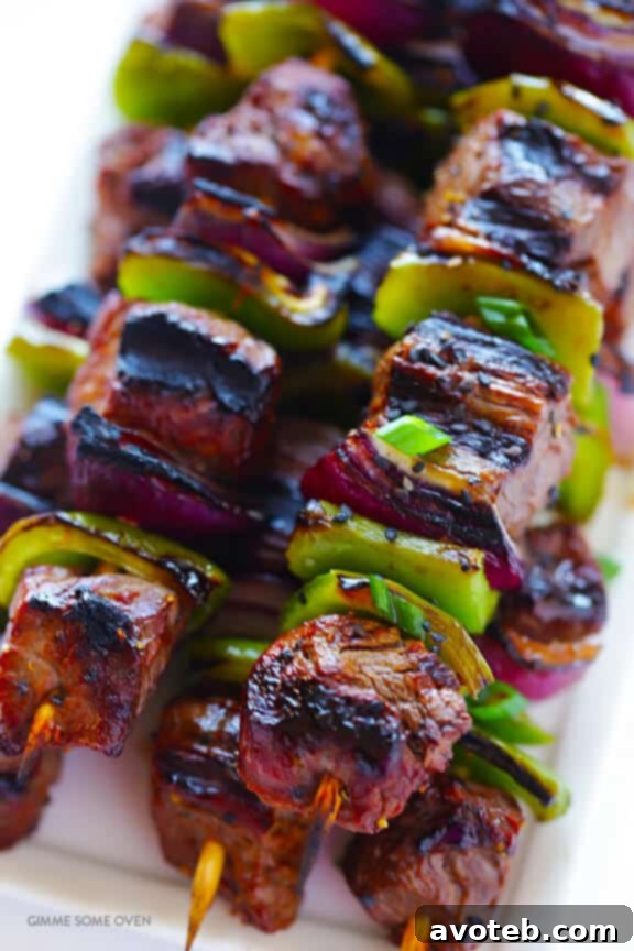 Assembling Asian Pepper Steak Kabobs on metal skewers for grilling