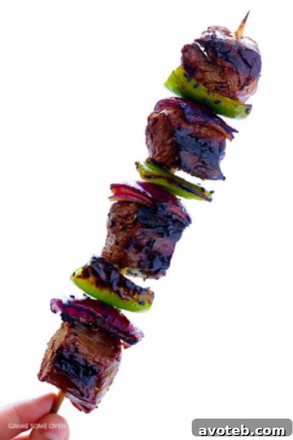 Brushed Asian Pepper Steak Kabobs garnished with sesame seeds and green onions