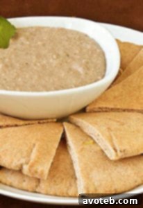 Black Bean Hummus garnished with fresh herbs in a white bowl.