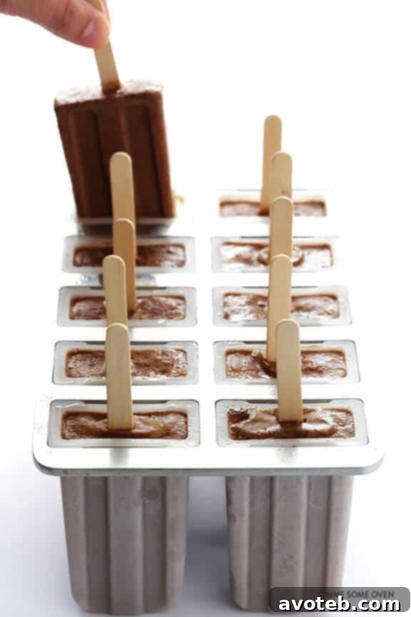Pouring chocolate peanut butter mixture into popsicle molds.