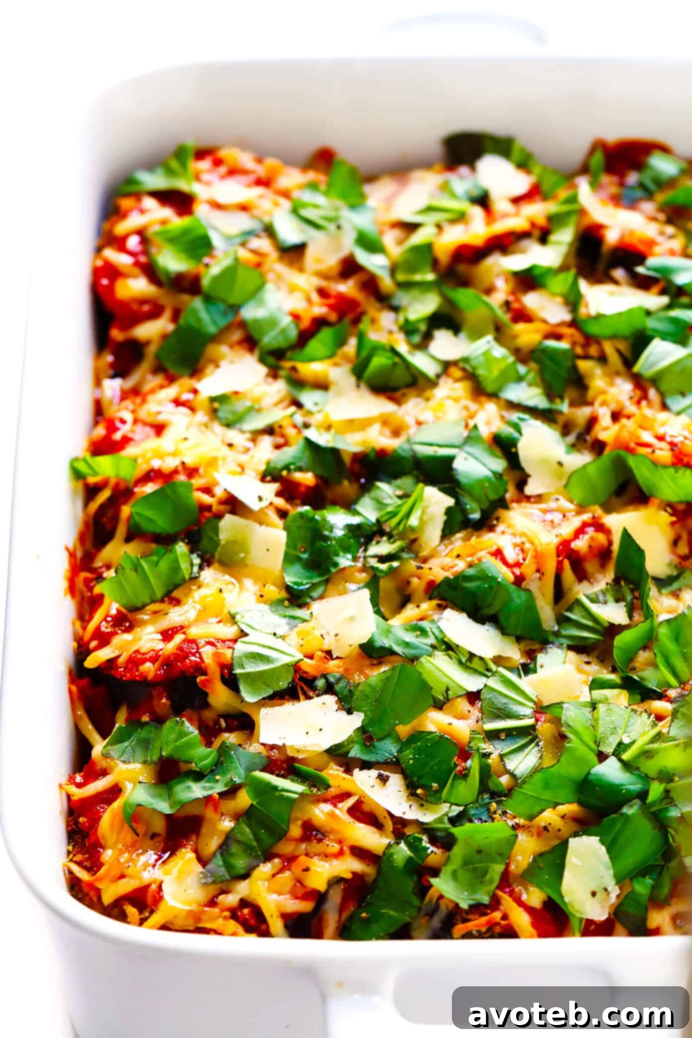 This Baked Eggplant Parmesan recipe is lightened up a bit with Panko-crusted baked (instead of fried) roasted eggplant, and layered with marinara tomato sauce, mozzarella cheese, fresh basil, and lots and lots of Parmesan. It's the perfect vegetarian casserole for Italian night, and always winner! | gimmesomeoven.com #eggplant #parmesan #vegetarian #casserole #glutenfree #italian #comfortfood #lasagna Best Ever Baked Eggplant Parmesan Recipe Garnished with Fresh Basil