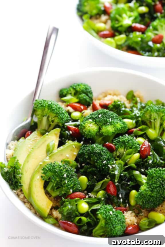 A vibrant close-up of the Superfood Quinoa Bowl, showcasing a medley of fresh greens, avocado slices, and edamame, drizzled with sesame vinaigrette.