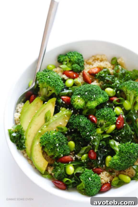 Drizzling homemade sesame-soy vinaigrette over a perfectly assembled Superfood Quinoa Bowl, adding the final touch of flavor.
