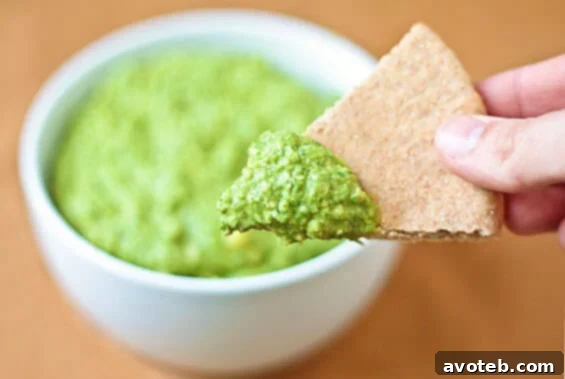 Creamy Spinach Artichoke Hummus served in a bowl with pita bread and fresh vegetables