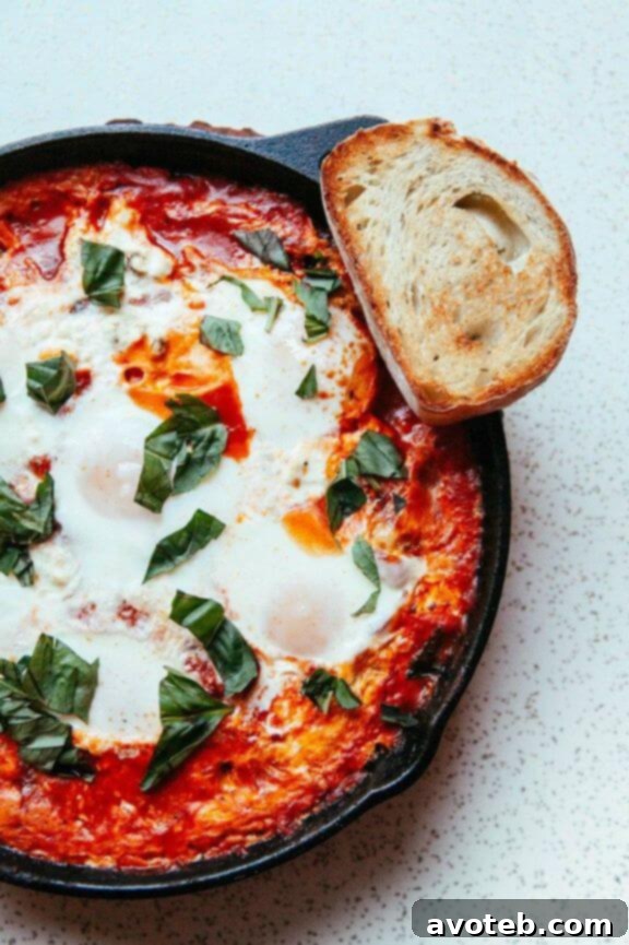 Cast Iron Baked Eggs in Tomato Sauce (Shakshuka), a vibrant and savory one-pan breakfast dish perfect for sharing on a weekend.