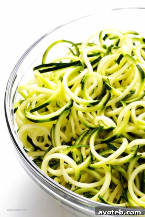 A mountain of green zucchini noodles, ready to be cooked into Zoodles Marinara. This recipe is naturally vegetarian and gluten-free.