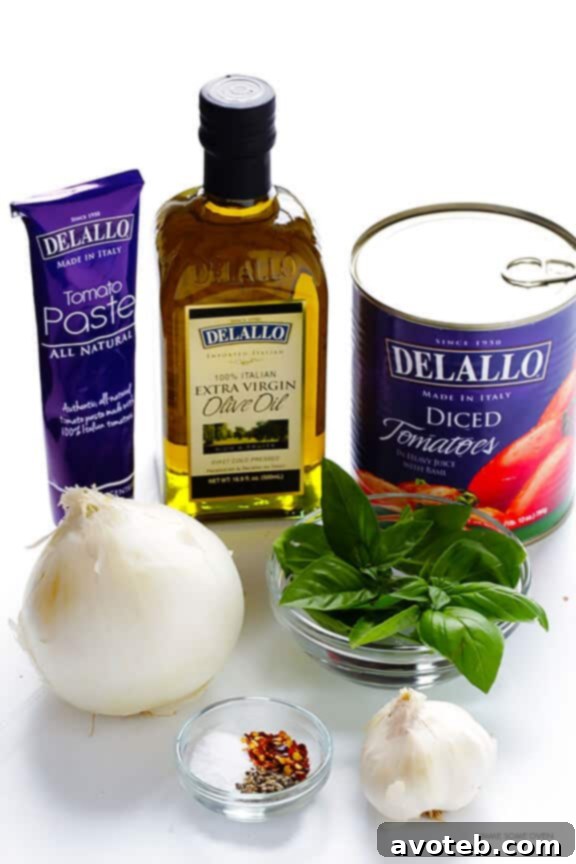 Preparing the rich and chunky marinara sauce for Zoodles Marinara. Featuring DeLallo tomatoes and tomato paste for authentic Italian flavor.