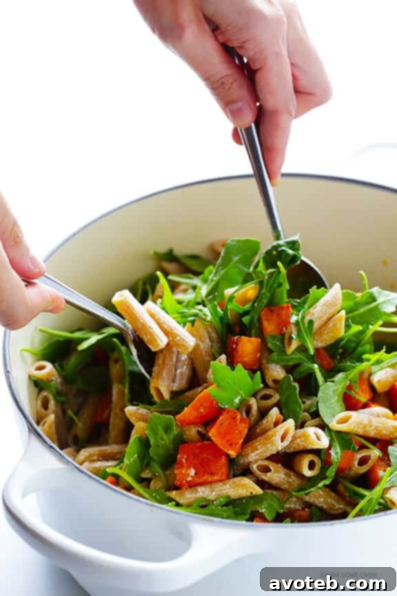 5-Ingredient Butternut Squash Pasta with Arugula and Goat Cheese 6 Close-up shot of the mixed pasta with butternut squash, arugula, and goat cheese in a large pot, before serving