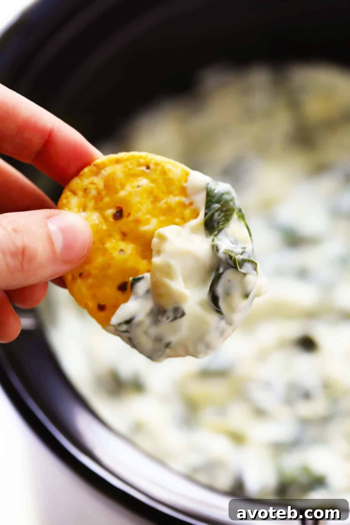 Serving Easy Slow Cooker Spinach Artichoke Dip A bowl of hot, bubbling Easy Spinach Artichoke Dip served with tortilla chips