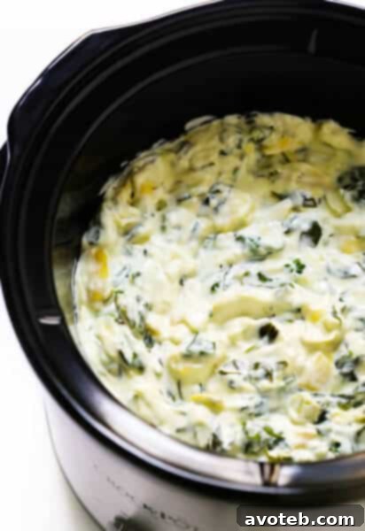 Slow Cooker Spinach Artichoke Dip recipe in a white slow cooker