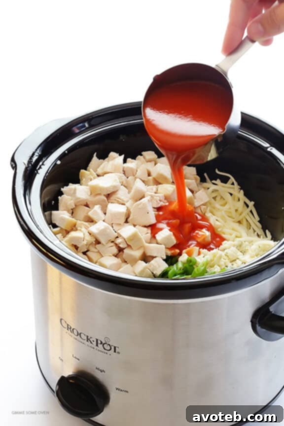Ultimate Buffalo Chicken Appetizer 3 Ingredients for Slow Cooker Buffalo Chicken Dip being added.