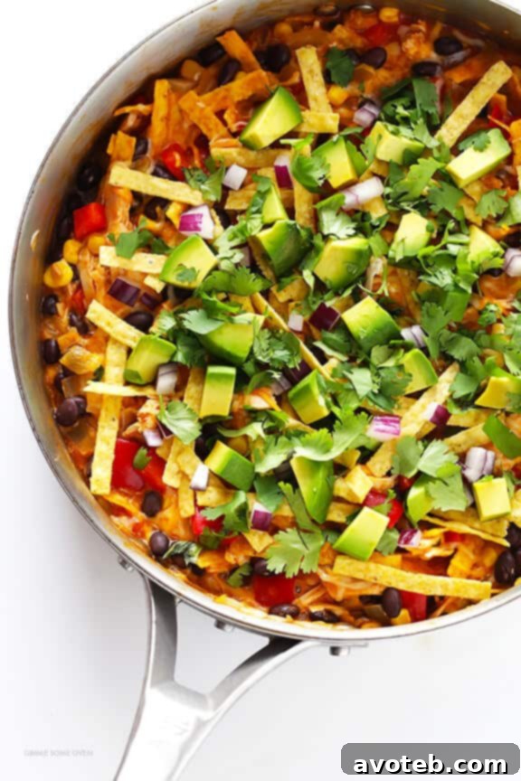 Ingredients being sautéed in a large skillet for Easy Chicken Enchilada Skillet