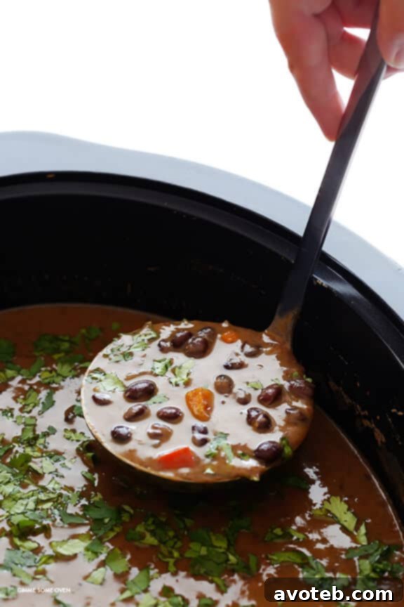Slow Cooker Black Bean Soup served with fresh cilantro and avocado – simple, delicious toppings.