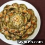 A perfectly cooked stuffed artichoke on a white plate.