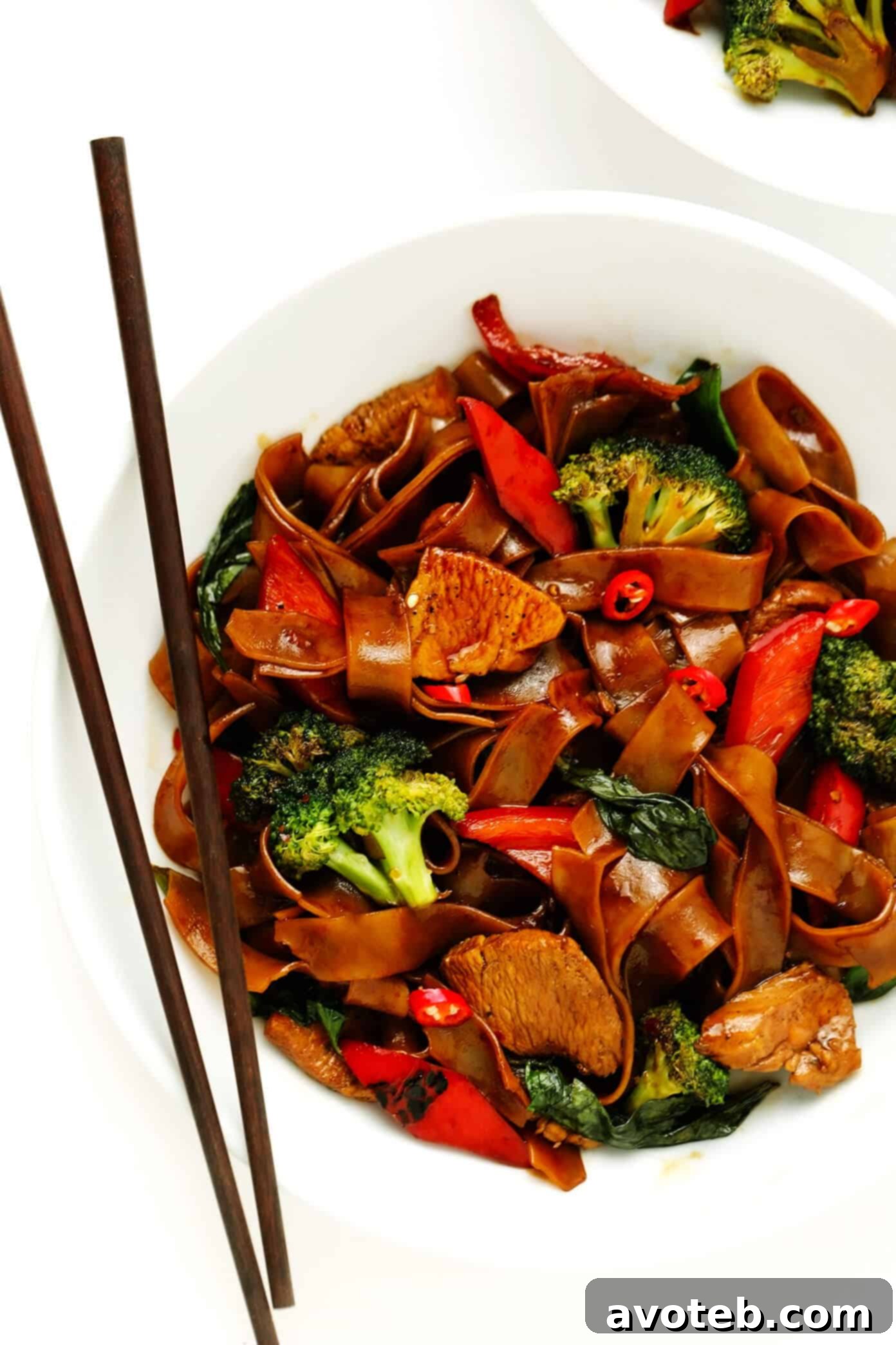 Serving bowl of Thai Drunken Noodles (Pad Kee Mao) with chopsticks, ready to eat.