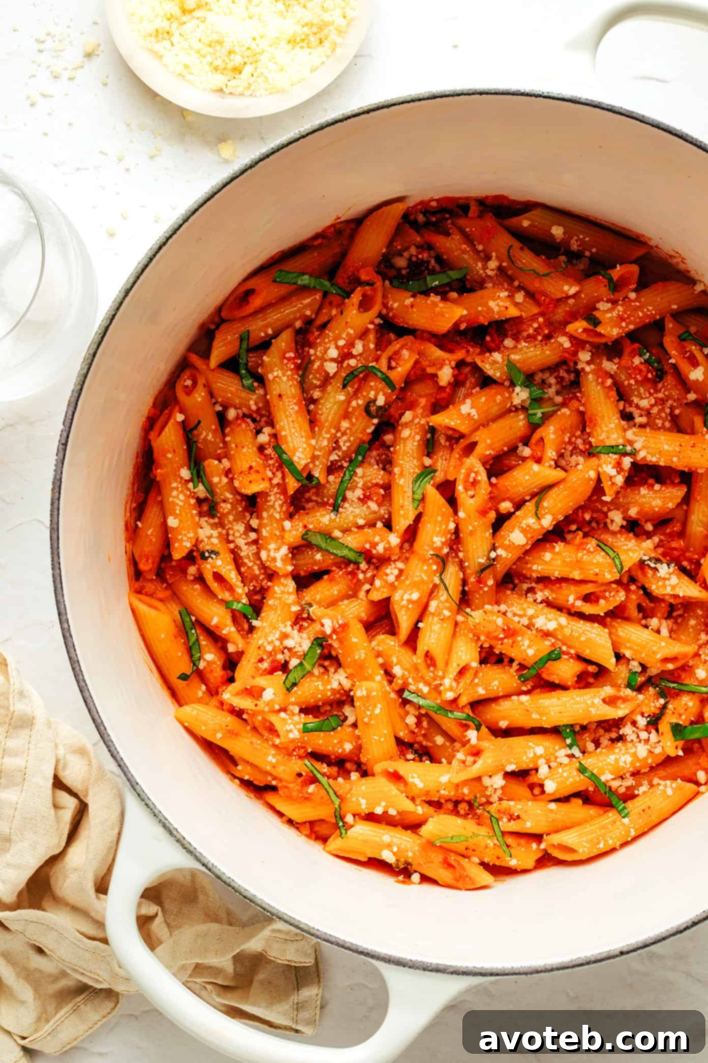 Cooking process of Penne Alla Vodka, showing the sauce simmering in a pan and pasta being tossed.