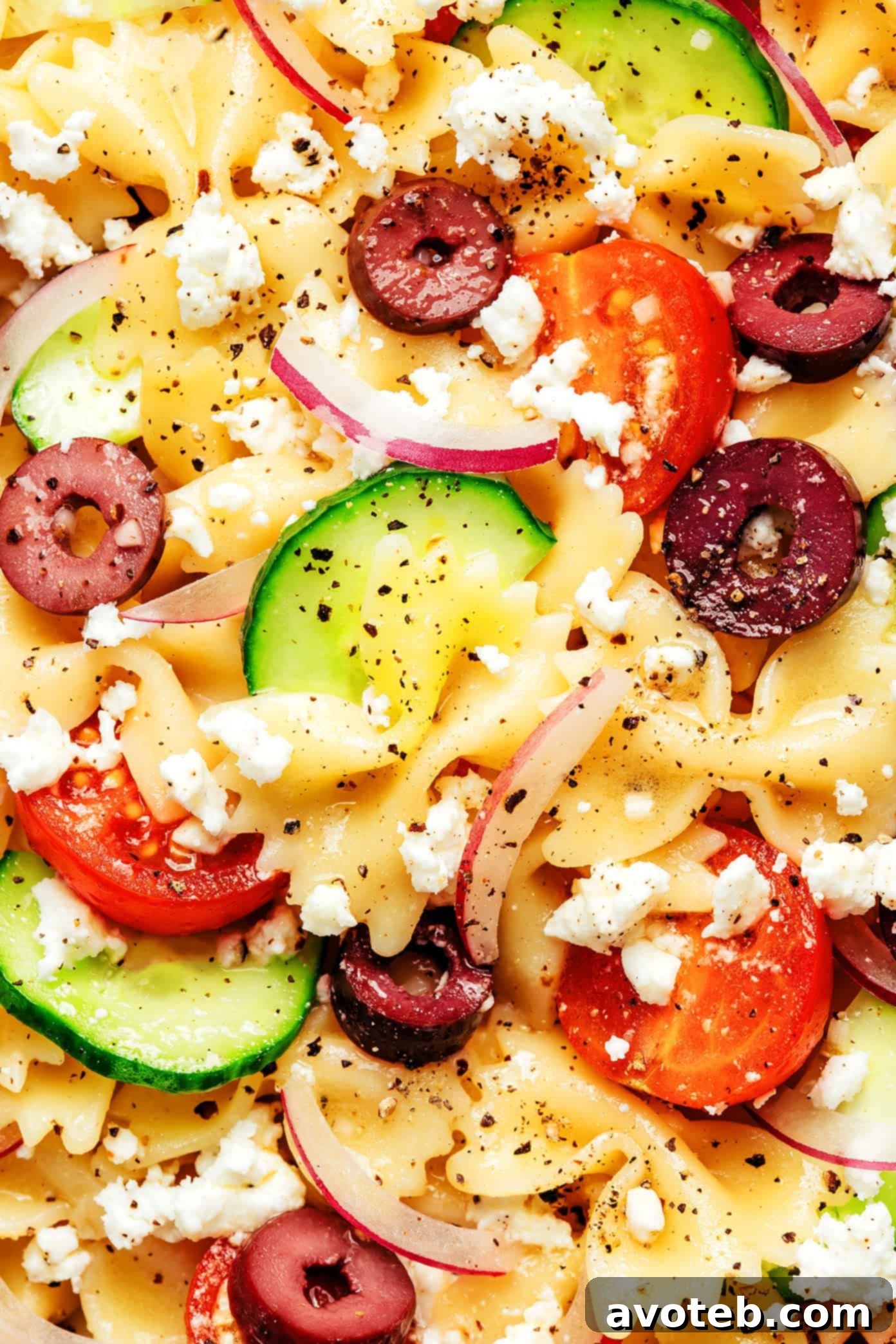 Serving bowl of Mediterranean Pasta Salad with a wooden spoon