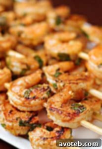 Chipotle Lime Shrimp skewers on a white plate with lime wedges.