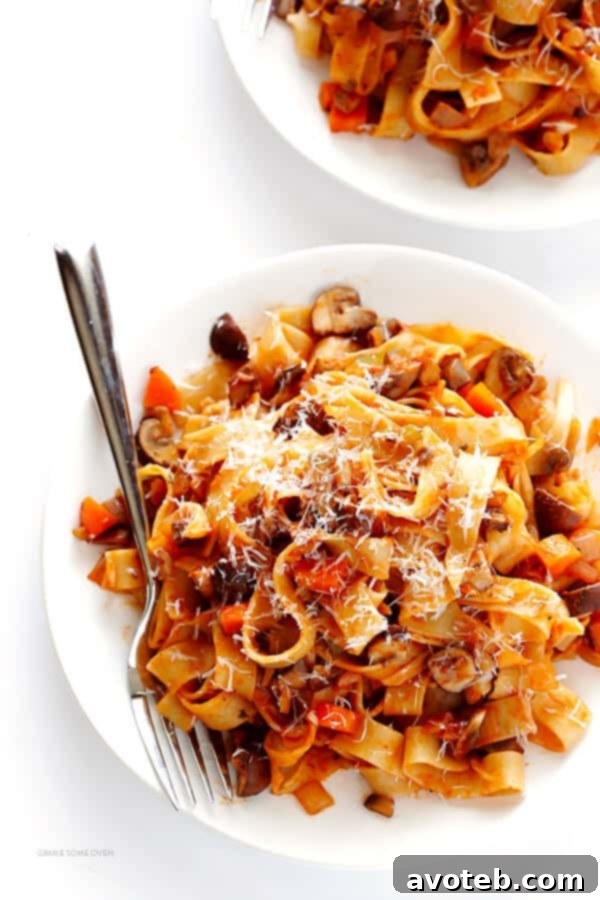 Hearty Mushroom Ragu 7 A bowl of Mushroom Bolognese pasta topped with fresh Parmesan cheese.