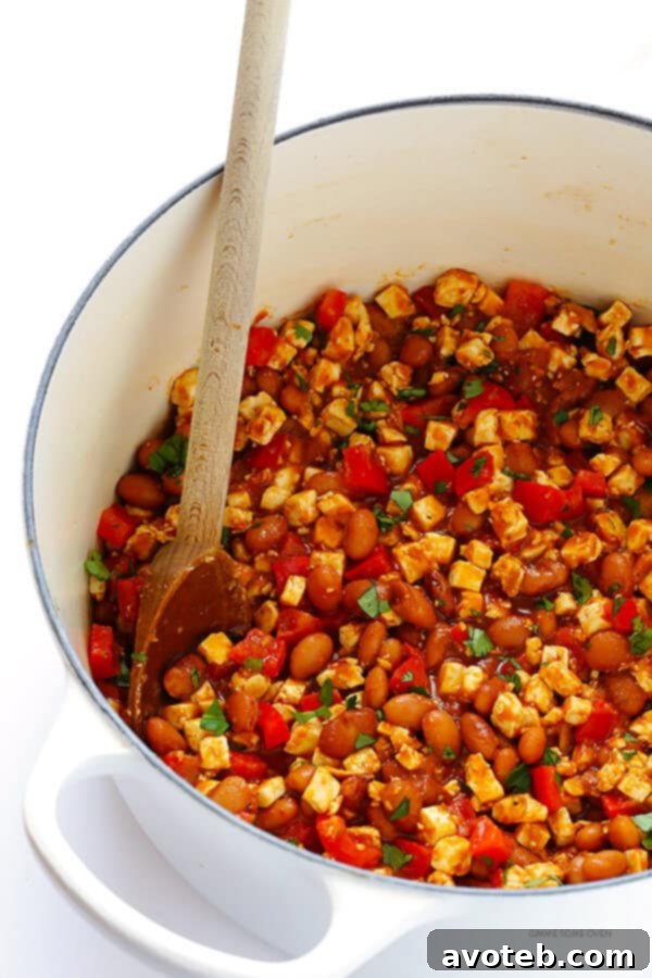 Chipotle Sofritas (tofu) filling stirred with beans, creating a protein-packed and flavorful taco base.