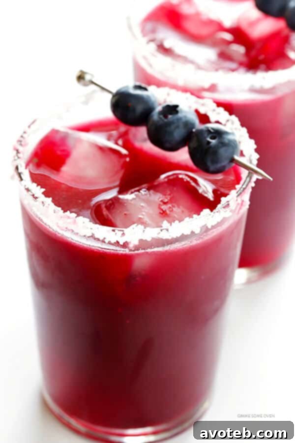 Refreshing Blueberry Margaritas in glasses, garnished with fresh blueberries and lime slices, ready for a festive celebration.