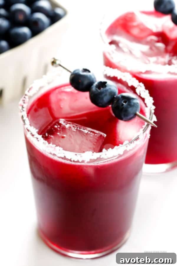 A close-up of a vibrant purple blueberry margarita, showcasing its rich color and refreshing appeal.