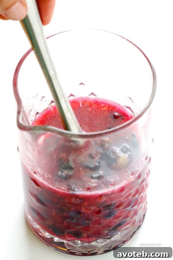 The process of blending blueberries and lime juice to create the base for homemade blueberry margaritas.