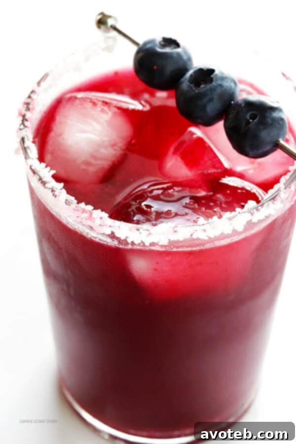 Straining the vibrant blueberry puree into a cocktail shaker, separating the juice from the pulp for a smooth margarita.
