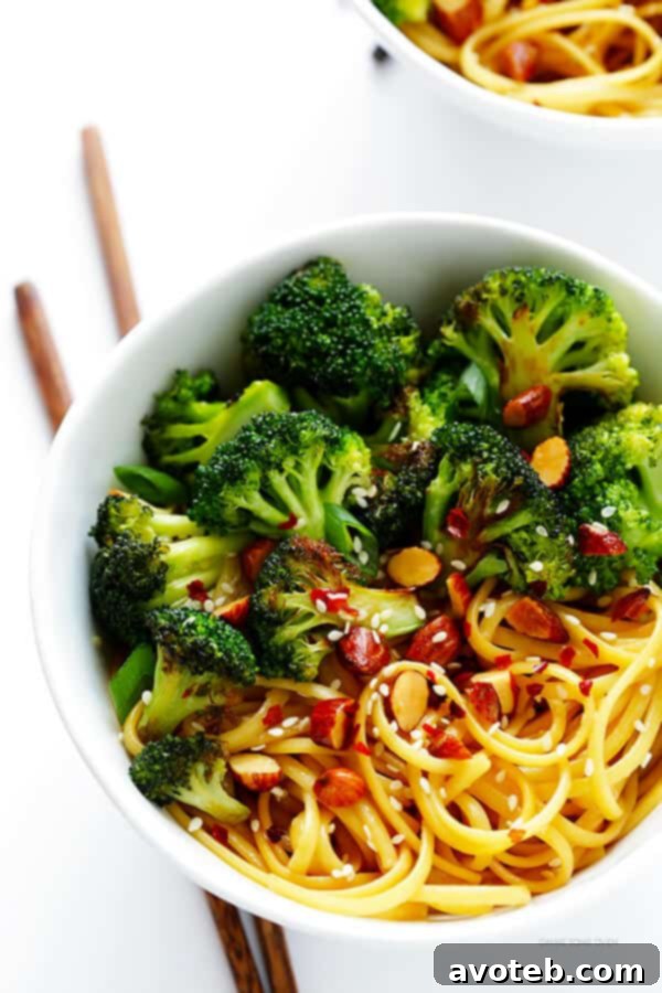 Ready-to-serve sesame noodle bowls, beautifully garnished with vibrant green onions, a sprinkle of toasted sesame seeds, and a touch of crushed red pepper flakes, showcasing a complete and appealing dish.