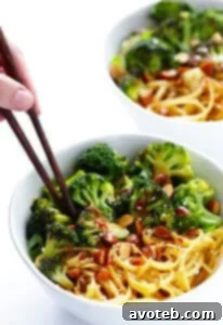 Close-up of Sesame Noodles with vibrant green broccoli florets and crunchy Wasabi and Soy Sauce Almonds, ready to be served.