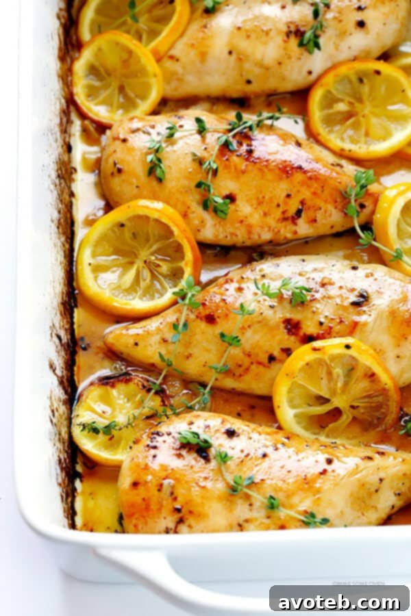Baked Lemon Chicken breasts in a baking dish, freshly basted