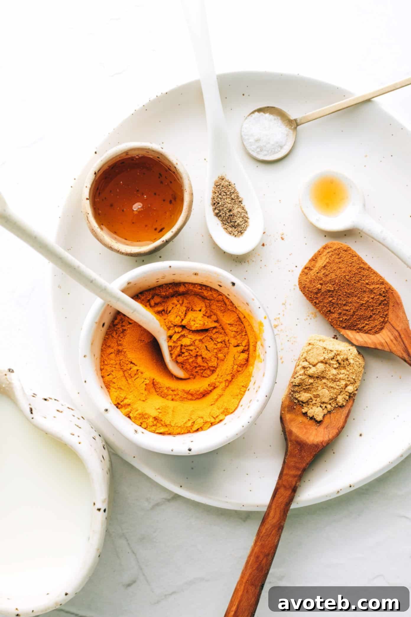 Ingredients for golden milk laid out: various spices, fresh turmeric, and milk.