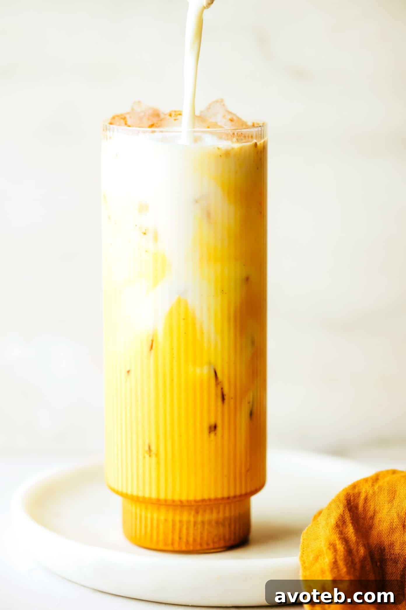 A mug of hot golden milk with a spoon, highlighting its creamy texture.