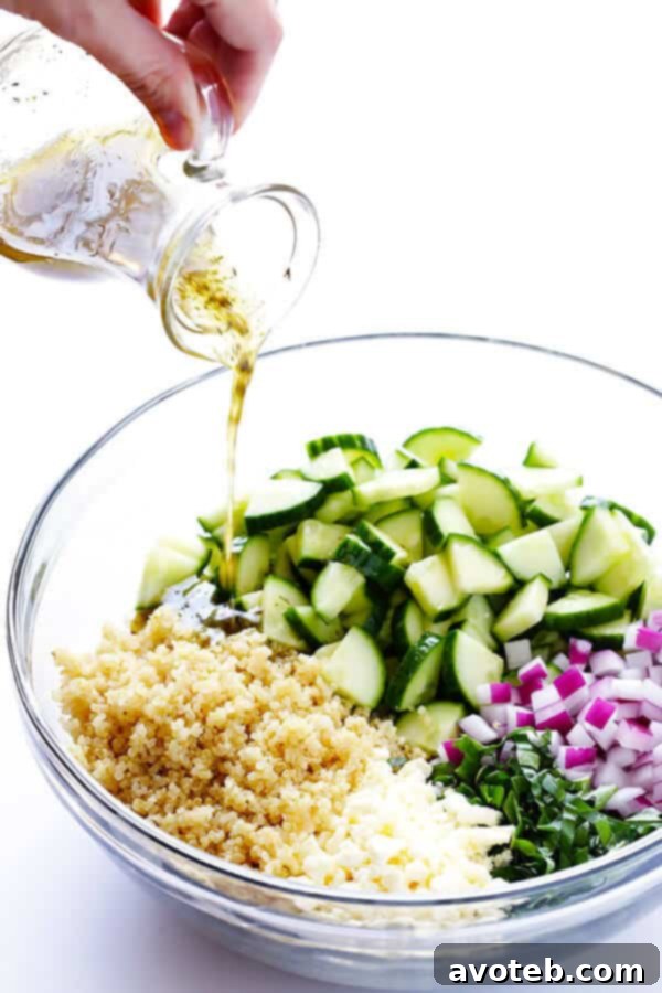 Vibrant Quinoa Cucumber Medley 4 Preparation step: Freshly chopped cucumber, red onion, basil, and feta cheese ready to be mixed with chilled quinoa.