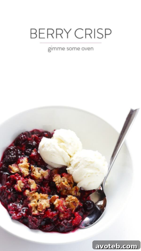 Close-up of Berry Almond Crisp with a scoop of vanilla ice cream, ready to be enjoyed.