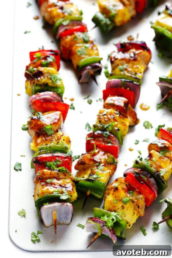 Skewers loaded with marinated chicken pieces and brightly colored vegetables ready for grilling.