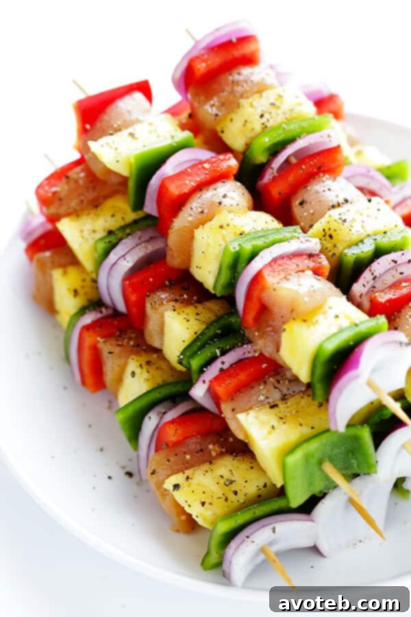 Chicken, red bell pepper, pineapple, green bell pepper, and red onion perfectly threaded onto a skewer, creating a vibrant rainbow pattern.