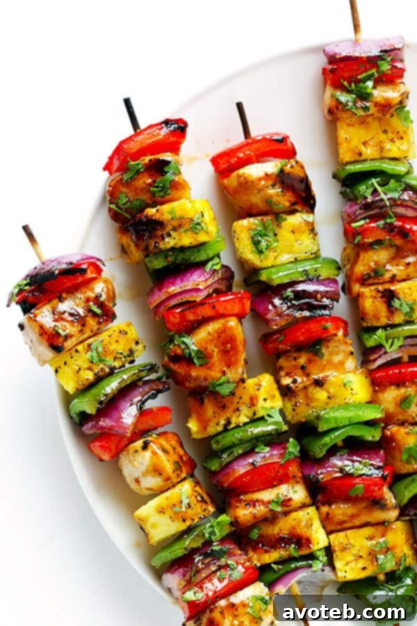 Several assembled Rainbow Hawaiian Chicken Kabobs ready to be placed on the hot grill.