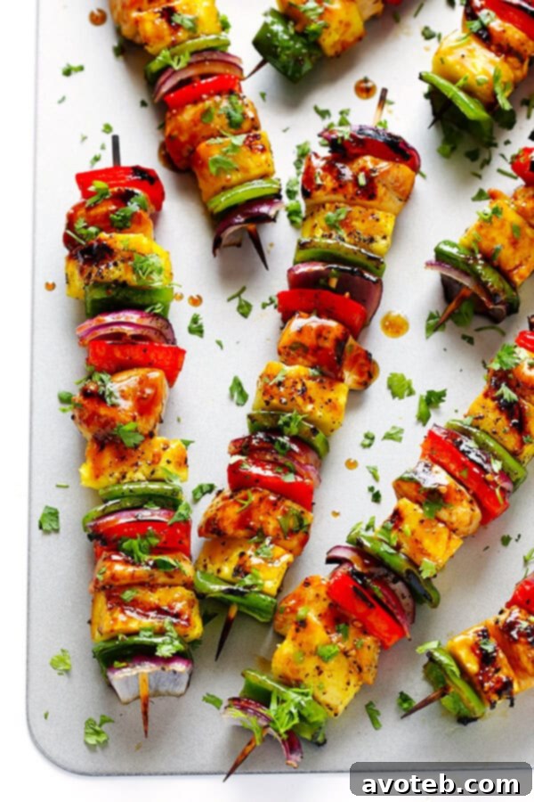 Perfectly grilled Rainbow Hawaiian Chicken Kabobs, beautifully charred and glistening with sauce, sprinkled with fresh cilantro.