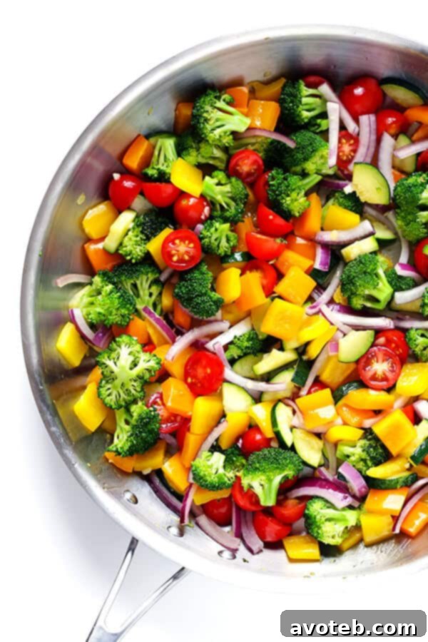 A selection of fresh vegetables including zucchini, broccoli, bell peppers, and tomatoes, ready to be prepared for the Veggie Lovers' Pasta Salad.